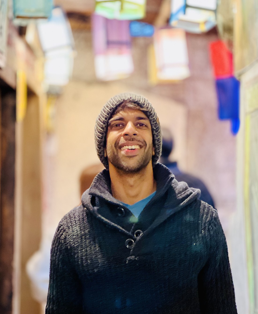 Varun Das smiling in a lantern-lit alleyway